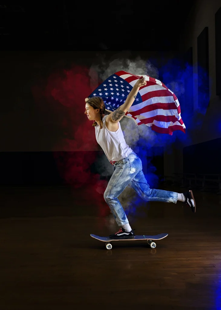 Sports Rock Media Photography: Girl skating while holding the American Flag.