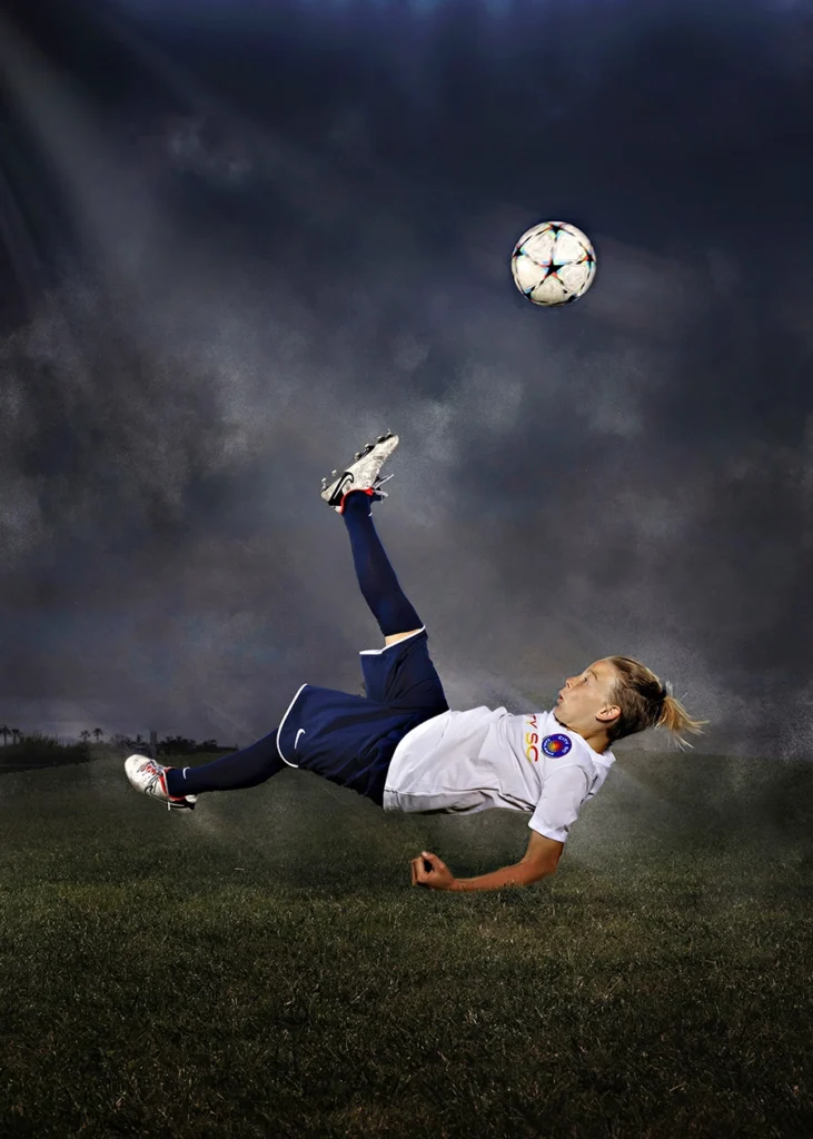 Sports Rock Media Photography: Soccer player kicking ball in the air.